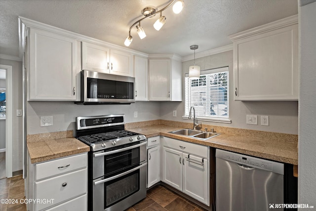 19237 Beverly Ave, Chugiak, AK 99567 - kitchen featuring stainless steel appliances, tile countertops, white cabinets, ornamental molding, and a textured ceiling