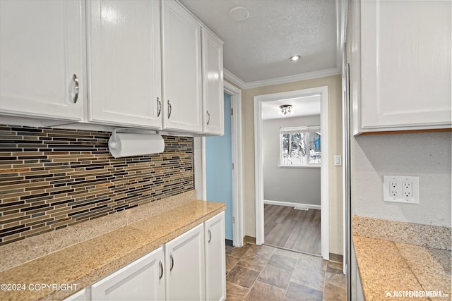 19237 Beverly Ave, Chugiak, AK 99567 - kitchen featuring white cabinets, ornamental molding, backsplash, a textured ceiling, and tile counters