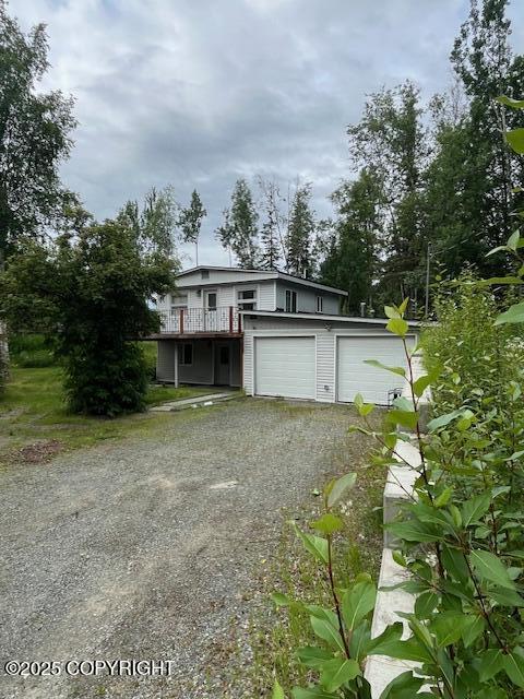 19237 Beverly Ave, Chugiak, AK 99567 - view of front of house featuring a garage, dirt driveway, and a wooden deck