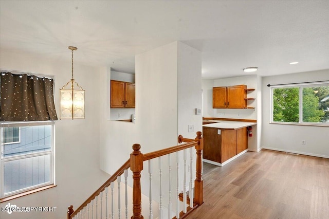 10270 Sextant Cir, Anchorage, AK 99515 - kitchen featuring brown cabinets, light wood-type flooring, open shelves, pendant lighting, and light countertops