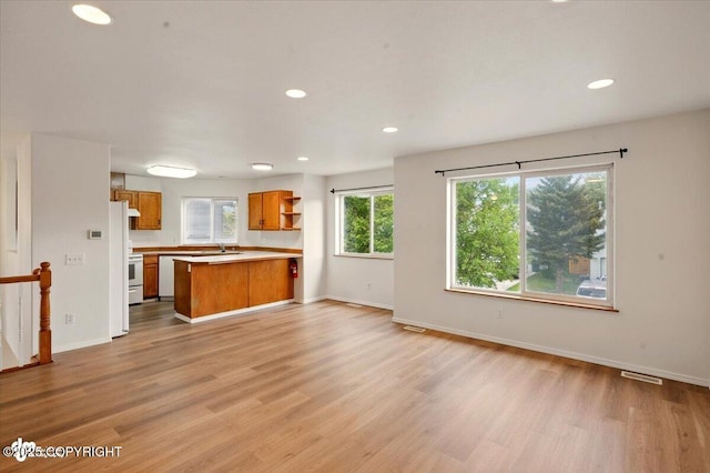 10270 Sextant Cir, Anchorage, AK 99515 - kitchen with open floor plan, brown cabinets, light wood-type flooring, open shelves, and light countertops