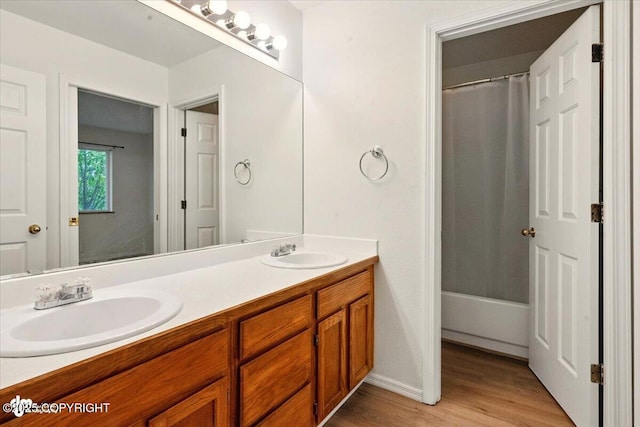 10270 Sextant Cir, Anchorage, AK 99515 - full bath featuring double vanity, wood finished floors, baseboards, and shower / bath combo with shower curtain
