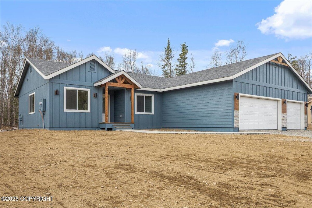 7875 E Obsidian Loop, Wasilla, AK 99654 - view of front of house featuring board and batten siding, an attached garage, and a shingled roof