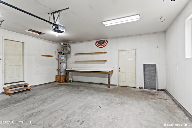 4470 E Birchwood Dr, Wasilla, AK 99654 - garage featuring a garage door opener, water heater, and a workshop area