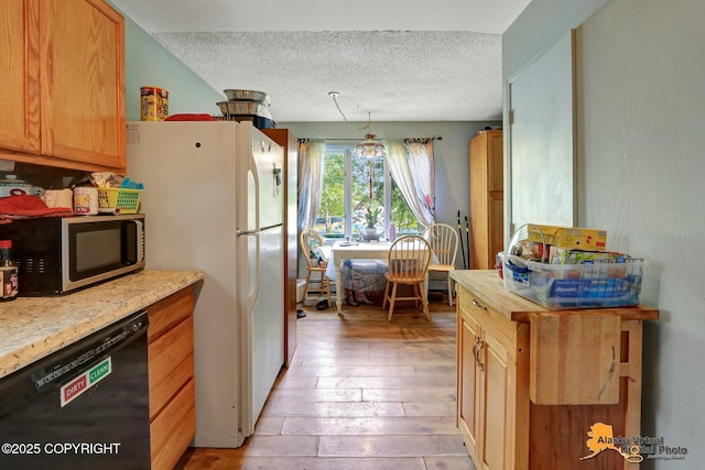 7510 Peck Ave, Anchorage, AK 99504 - kitchen with stainless steel microwave, black dishwasher, a textured ceiling, light wood-style floors, and freestanding refrigerator