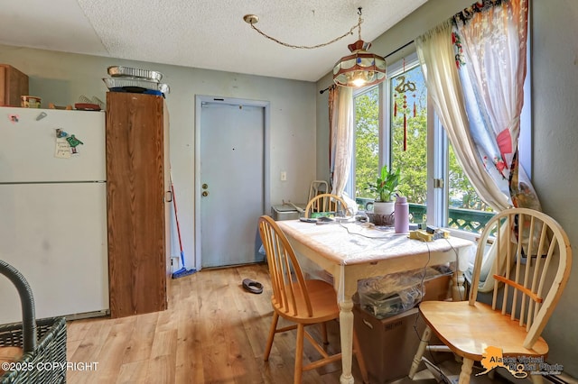 7510 Peck Ave, Anchorage, AK 99504 - dining area featuring light wood-type flooring and a textured ceiling