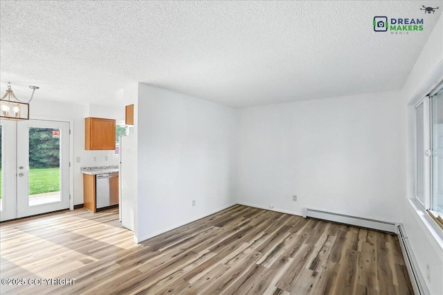 1918 Juneau Dr, Anchorage, AK 99501 - empty room featuring light wood finished floors, a textured ceiling, a baseboard radiator, and a chandelier