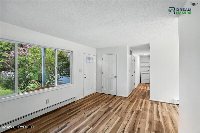 1918 Juneau Dr, Anchorage, AK 99501 - entrance foyer featuring baseboard heating, washer / clothes dryer, wood finished floors, and a textured ceiling