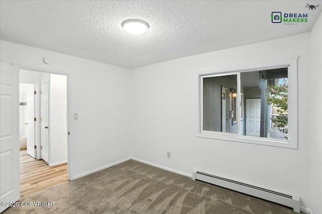 1918 Juneau Dr, Anchorage, AK 99501 - carpeted empty room featuring a baseboard radiator, a textured ceiling, and a smoke detector