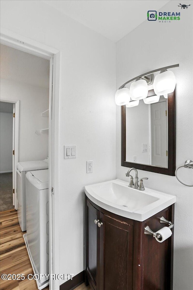1918 Juneau Dr, Anchorage, AK 99501 - bathroom featuring washer and clothes dryer, vanity, and wood finished floors