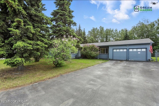 1918 Juneau Dr, Anchorage, AK 99501 - view of front facade featuring asphalt driveway, an attached garage, and a front yard