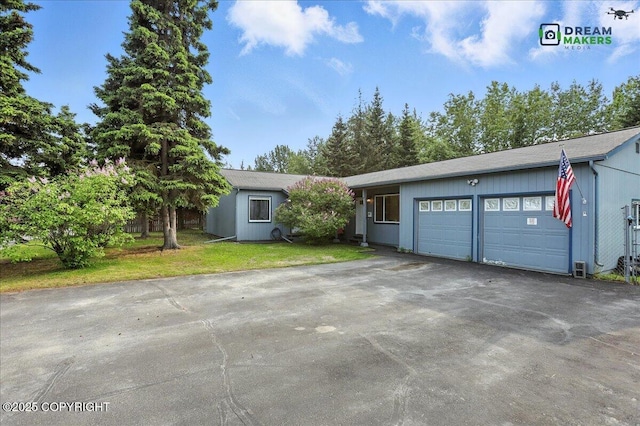 1918 Juneau Dr, Anchorage, AK 99501 - view of front facade featuring asphalt driveway, an attached garage, and a front yard