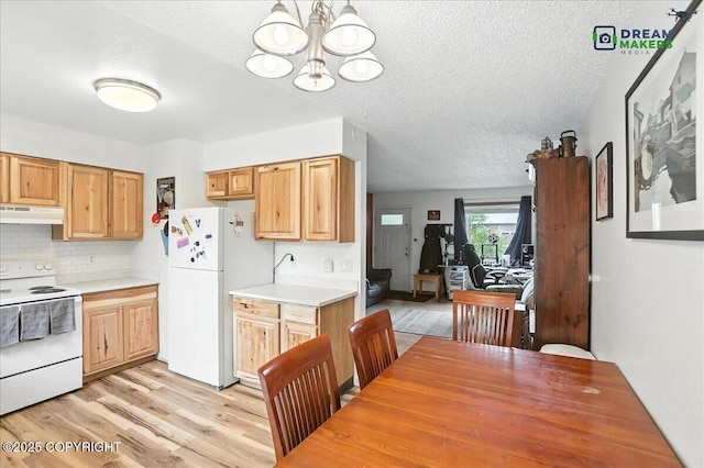 1918 Juneau Dr, Anchorage, AK 99501 - kitchen featuring white appliances, under cabinet range hood, a textured ceiling, light wood-style flooring, and light countertops