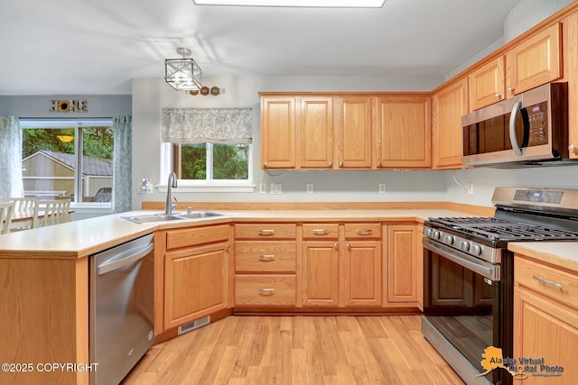 18924 Third St, Eagle River, AK 99577 - kitchen with stainless steel appliances, light wood-style floors, light countertops, and light brown cabinets
