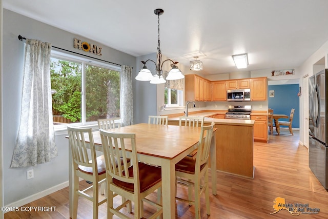 18924 Third St, Eagle River, AK 99577 - dining room with light wood-style flooring and a chandelier
