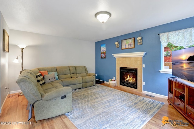 18924 Third St, Eagle River, AK 99577 - living room with a tiled fireplace and wood finished floors