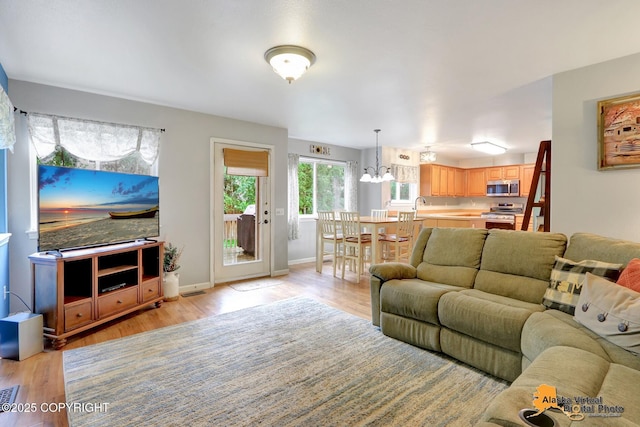 18924 Third St, Eagle River, AK 99577 - living room featuring light wood-style floors and a chandelier