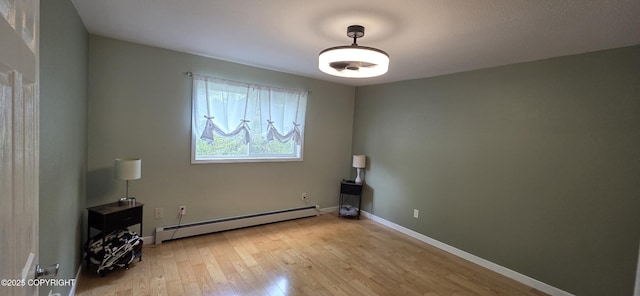 6905 Cape Lisburne Loop, Anchorage, AK 99504 - empty room with a baseboard heating unit, light wood-type flooring, and baseboards