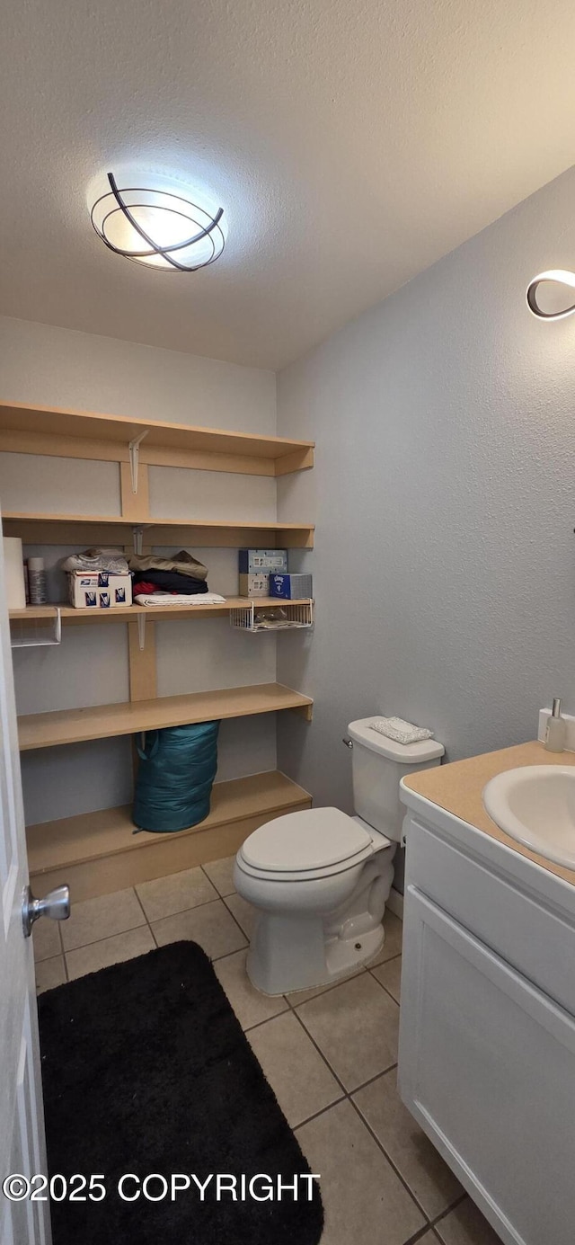 6905 Cape Lisburne Loop, Anchorage, AK 99504 - bathroom featuring vanity, tile patterned floors, toilet, and a textured ceiling