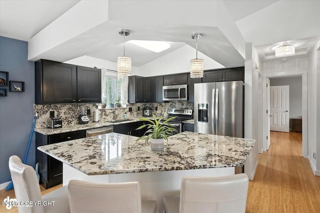 8968 Little Brook St, Anchorage, AK 99507 - kitchen featuring appliances with stainless steel finishes, light wood-type flooring, light stone countertops, backsplash, and pendant lighting