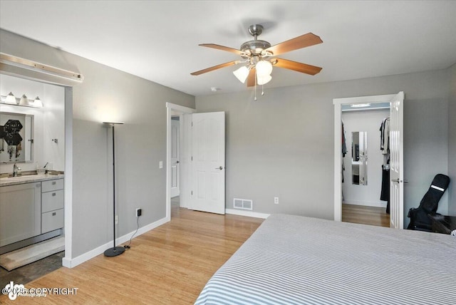 8968 Little Brook St, Anchorage, AK 99507 - bedroom featuring light wood finished floors, ensuite bathroom, a spacious closet, and ceiling fan