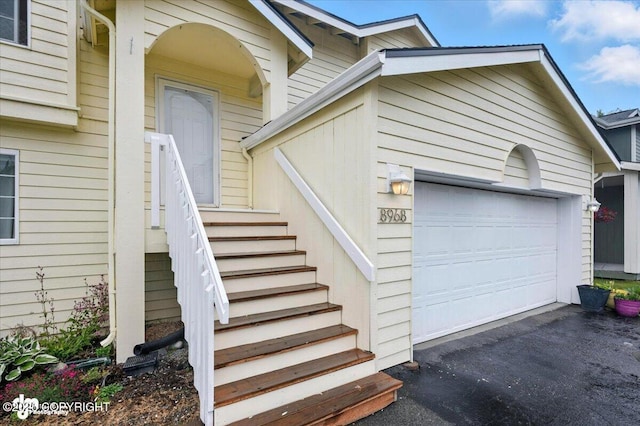 8968 Little Brook St, Anchorage, AK 99507 - view of exterior entry featuring asphalt driveway and an attached garage