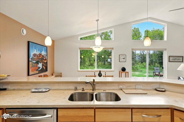 48585 Runners Ave, Soldotna, AK 99669 - kitchen featuring stainless steel dishwasher, a sink, lofted ceiling, light stone counters, and hanging light fixtures
