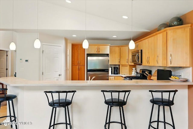 48585 Runners Ave, Soldotna, AK 99669 - kitchen with appliances with stainless steel finishes, a peninsula, lofted ceiling, light countertops, and recessed lighting