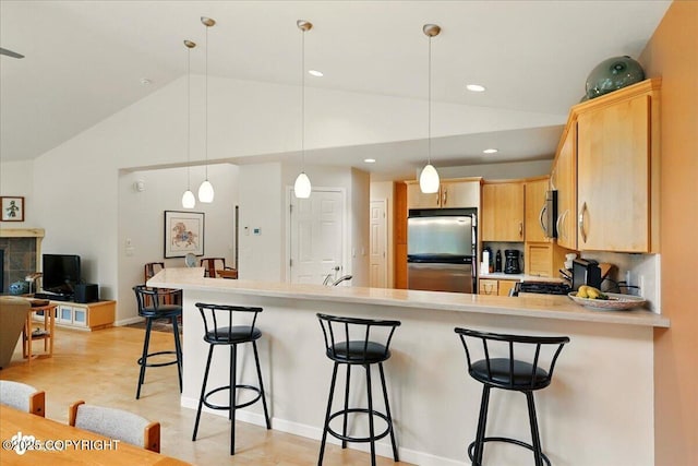 48585 Runners Ave, Soldotna, AK 99669 - kitchen with appliances with stainless steel finishes, vaulted ceiling, a sink, light brown cabinets, and a peninsula