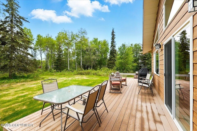 48585 Runners Ave, Soldotna, AK 99669 - deck featuring outdoor dining area, a yard, and view of wooded area