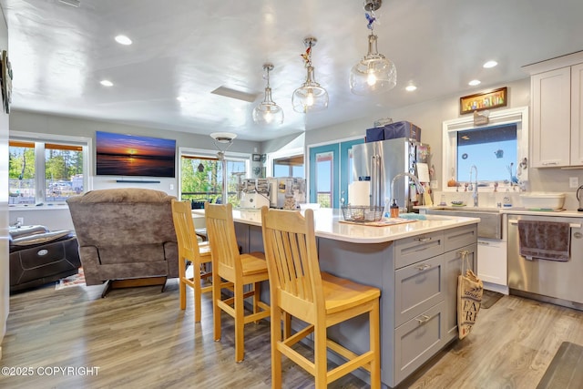 9291 Basher Dr, Anchorage, AK 99507 - kitchen featuring appliances with stainless steel finishes, open floor plan, a sink, a breakfast bar, and light countertops
