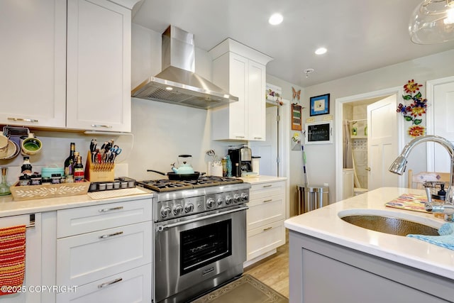 9291 Basher Dr, Anchorage, AK 99507 - kitchen featuring wall chimney range hood, a sink, high end stainless steel range, light countertops, and recessed lighting