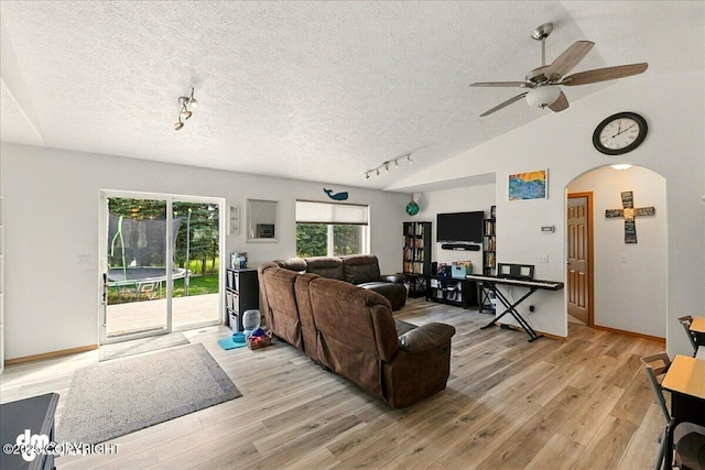 1213 Channel Way, Kenai, AK 99611 - living area featuring arched walkways, light wood finished floors, a textured ceiling, a ceiling fan, and rail lighting