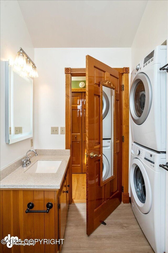 40327 S Malaspina Loop, Talkeetna, AK 99676 - washroom featuring stacked washing machine and dryer and light wood finished floors