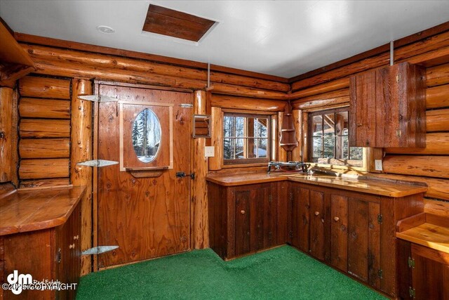 40327 S Malaspina Loop, Talkeetna, AK 99676 - kitchen featuring log walls and brown cabinets