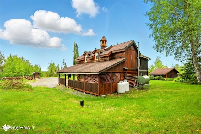 40327 S Malaspina Loop, Talkeetna, AK 99676 - rear view of property with a lawn, an outdoor structure, log exterior, and heating fuel
