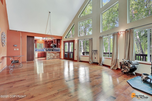 7408 N Grouse Loop, Wasilla, AK 99654 - living area with a towering ceiling, light wood-style flooring, and plenty of natural light