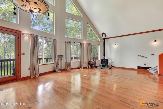 7408 N Grouse Loop, Wasilla, AK 99654 - living area featuring a high ceiling, a wood stove, and hardwood / wood-style flooring