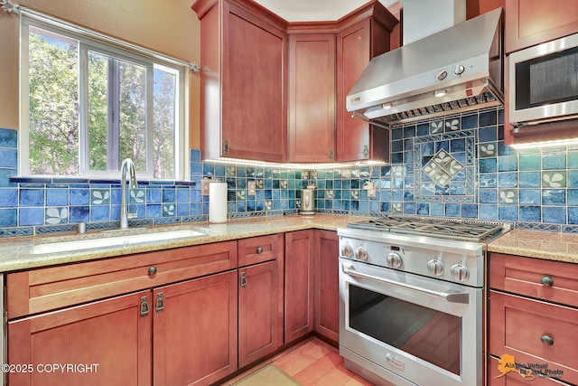 7408 N Grouse Loop, Wasilla, AK 99654 - kitchen featuring appliances with stainless steel finishes, wall chimney exhaust hood, decorative backsplash, light stone countertops, and brown cabinetry