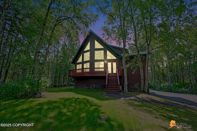 7408 N Grouse Loop, Wasilla, AK 99654 - back of house at dusk featuring stairway, a wooden deck, and a lawn