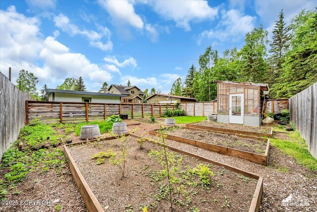 1601 Bannister Dr, Anchorage, AK 99508 - fenced backyard featuring a garden and an outdoor structure