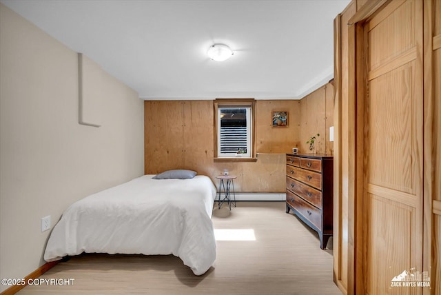 1601 Bannister Dr, Anchorage, AK 99508 - bedroom featuring a baseboard radiator, light wood-style floors, and wood walls