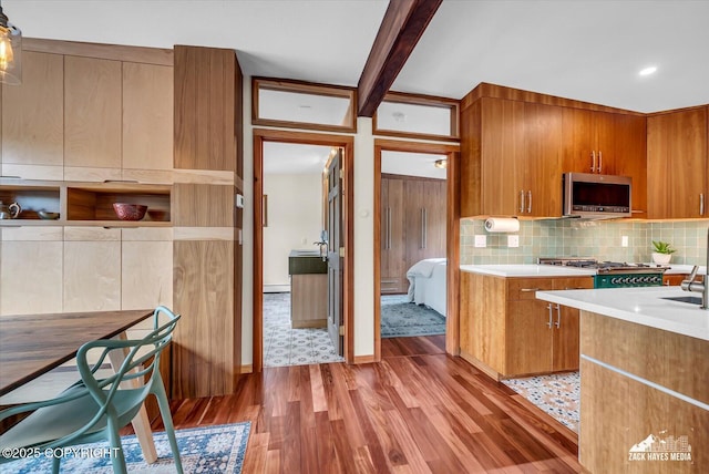 1601 Bannister Dr, Anchorage, AK 99508 - kitchen featuring stainless steel microwave, wood finished floors, tasteful backsplash, and brown cabinetry