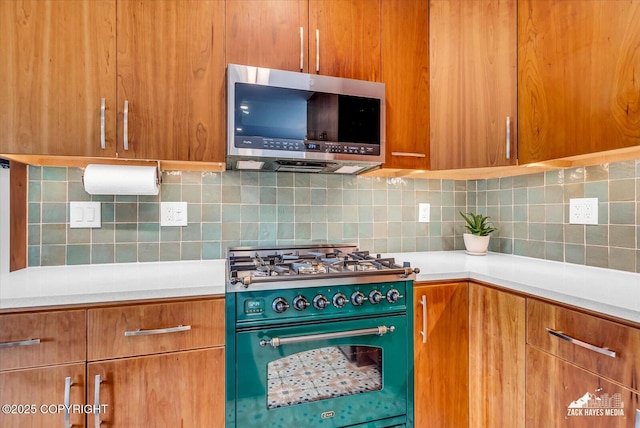 1601 Bannister Dr, Anchorage, AK 99508 - kitchen featuring stainless steel microwave, range with gas cooktop, light countertops, backsplash, and brown cabinets