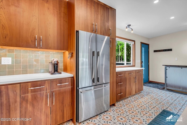 1601 Bannister Dr, Anchorage, AK 99508 - kitchen featuring stainless steel fridge, brown cabinets, light countertops, decorative backsplash, and recessed lighting