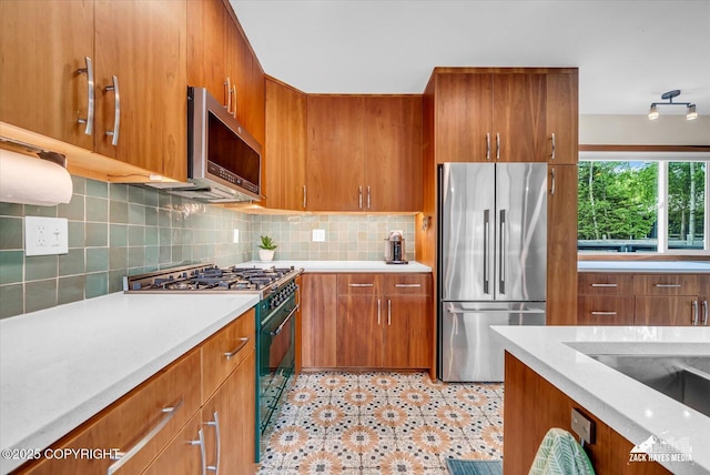 1601 Bannister Dr, Anchorage, AK 99508 - kitchen with stainless steel appliances, brown cabinetry, and decorative backsplash