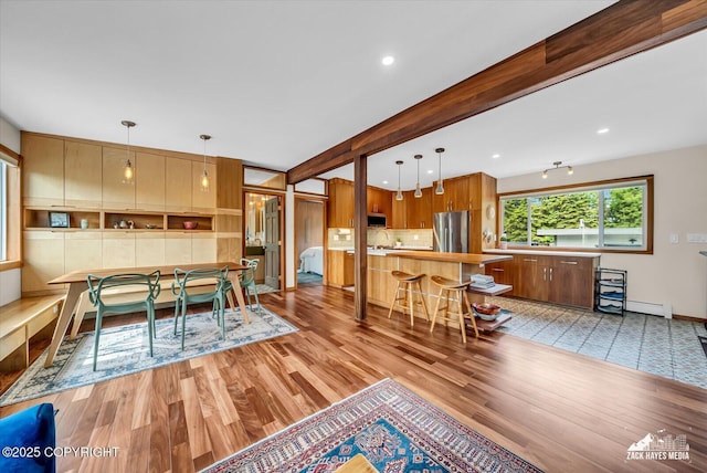 1601 Bannister Dr, Anchorage, AK 99508 - dining room featuring light wood finished floors, a baseboard radiator, recessed lighting, beamed ceiling, and baseboards