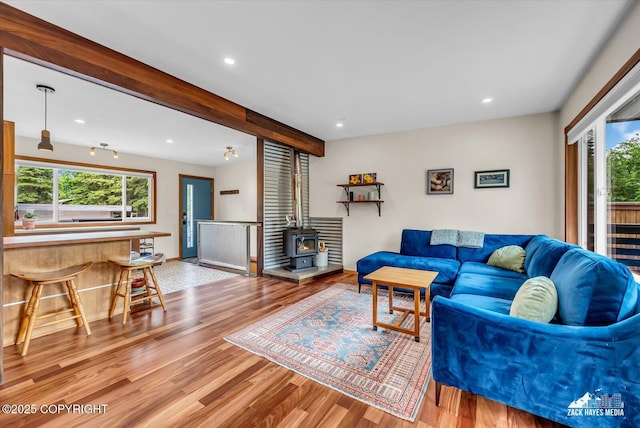 1601 Bannister Dr, Anchorage, AK 99508 - living area featuring wood finished floors, a wood stove, beamed ceiling, and recessed lighting