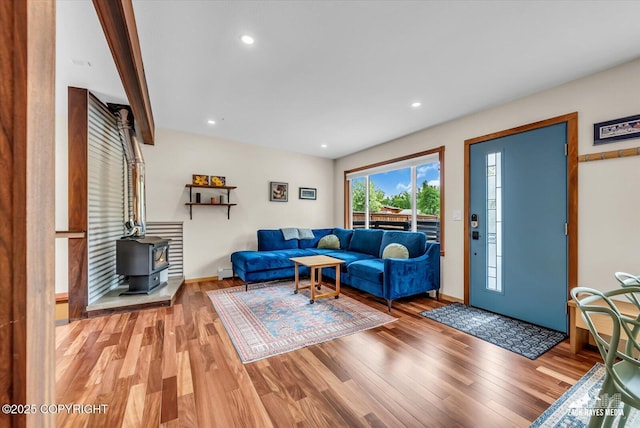 1601 Bannister Dr, Anchorage, AK 99508 - living room featuring light wood-style flooring, a wood stove, baseboards, baseboard heating, and recessed lighting