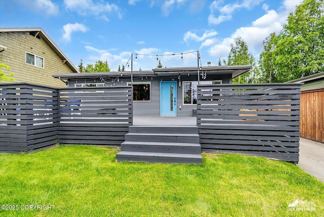 1601 Bannister Dr, Anchorage, AK 99508 - back of property featuring a wooden deck and a lawn